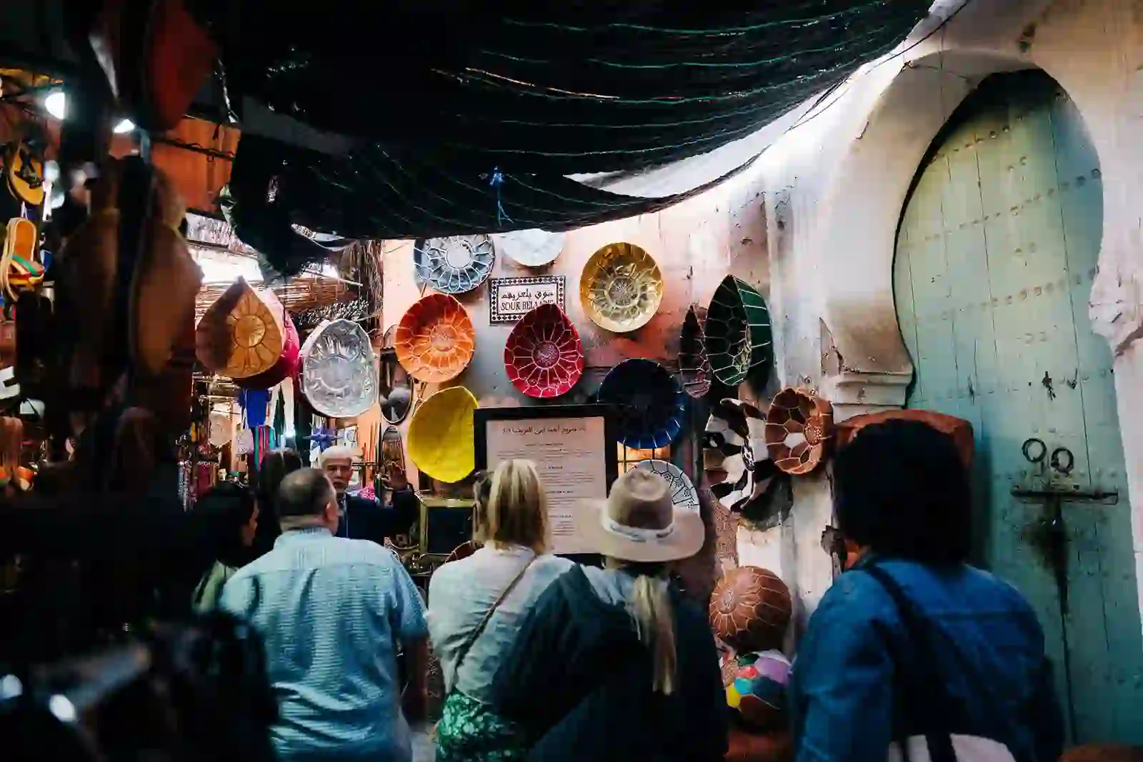 Souk Experience Cultural Discoveries Travelers exploring a Moroccan souk filled with leather goods and crafts.